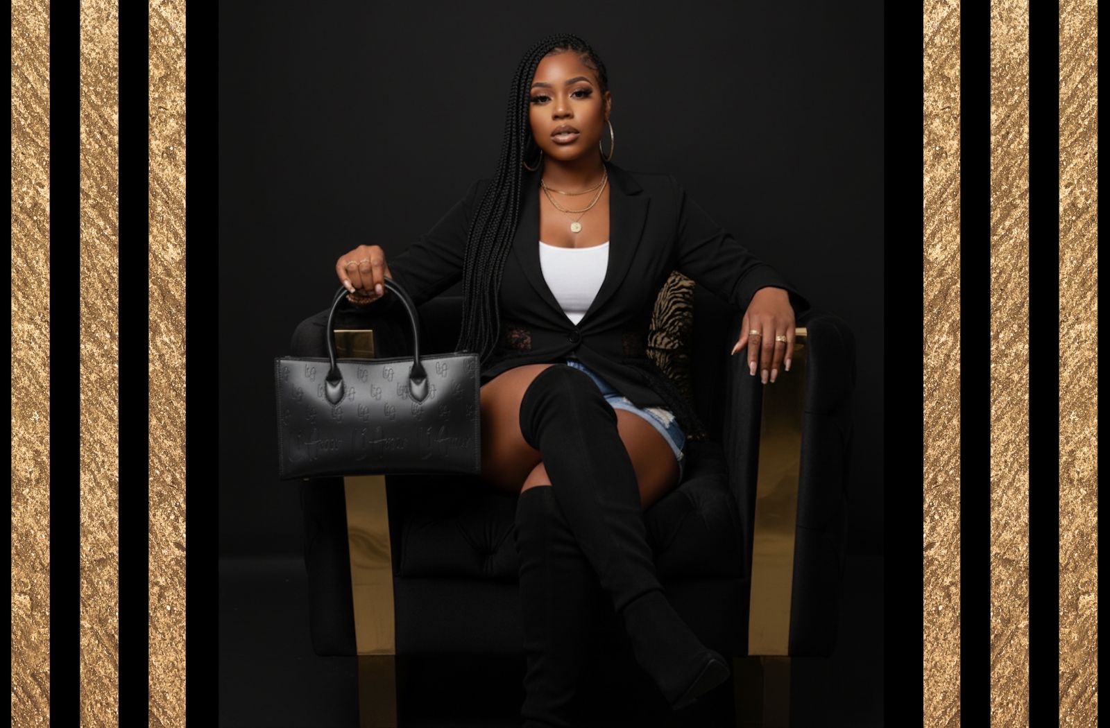 Li Amor model sitting in an elegant chair holding the black leather, large Li Amor messenger handbag- BOSS Bag