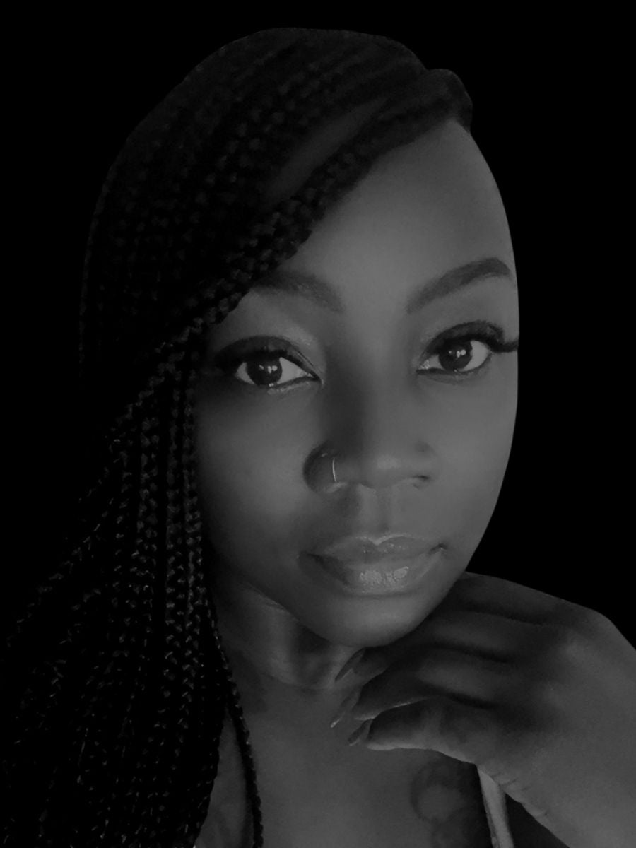 Black and white portrait of Lia, the owner of Li Amor, with braided hair and hand on chin.